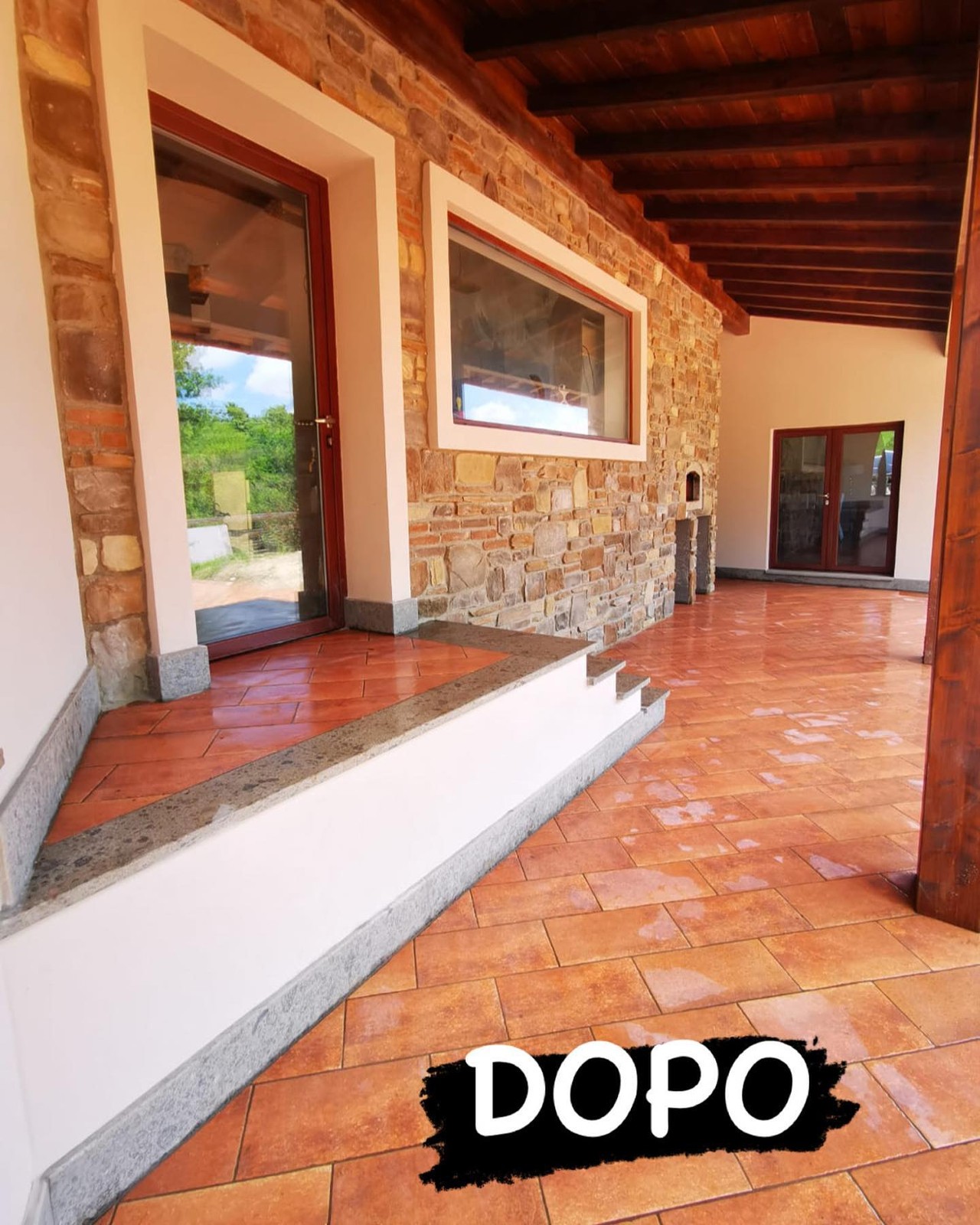 Portico con pavimento in cotto e parete rivestita in pietra dopo i lavori